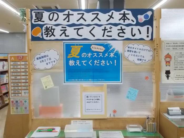 POPを書くためのスペースの写真です。記載台に大きく「夏のオススメ本、教えてください！」とイベント名の看板を掲げています。