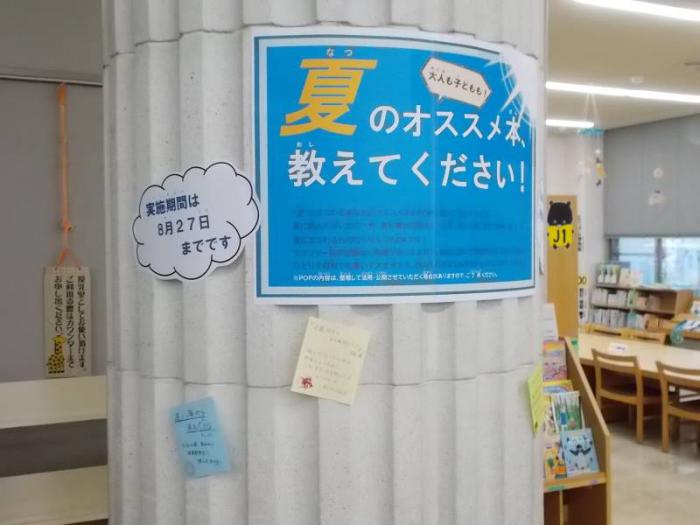夏のPOP行事の掲出スペースの写真です。館内の大きな柱に、イベント名「夏のオススメ本、教えてください！」と書かれたポスターを掲出し、その周りにPOPを貼り出しています。