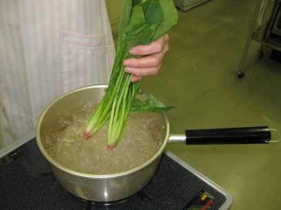 鍋でほうれん草を茹でる様子