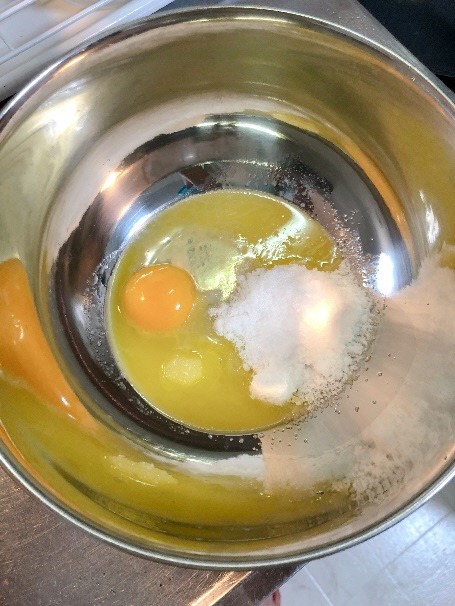 ボウルに卵、溶かしたバター、砂糖が入っている画像