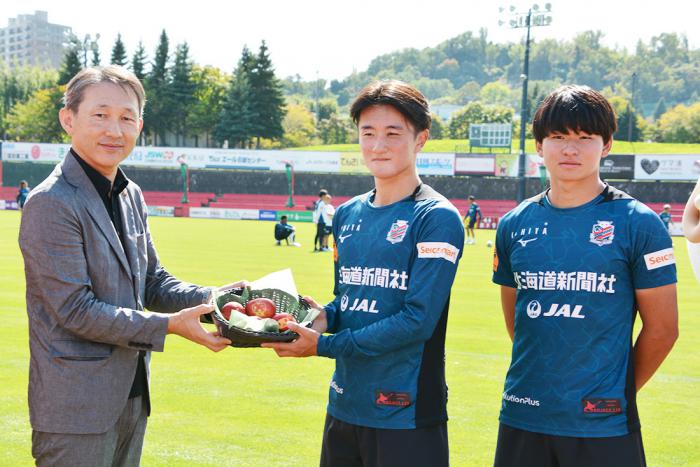 贈呈の様子（左から、石井区長、木戸選手、林田選手）